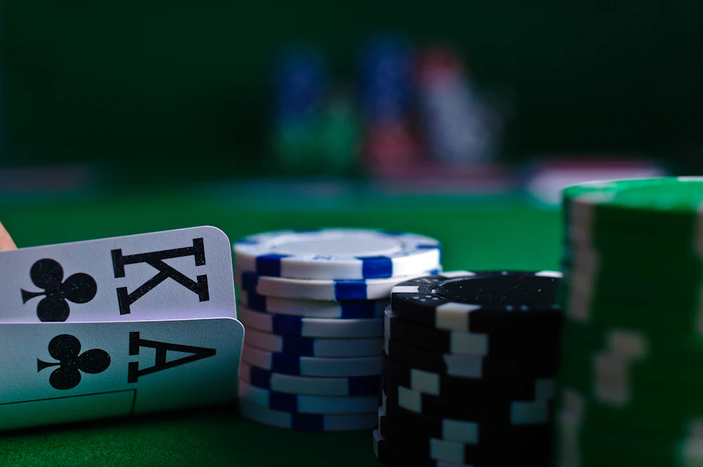 Kartu remi dan keripik poker di meja hijau